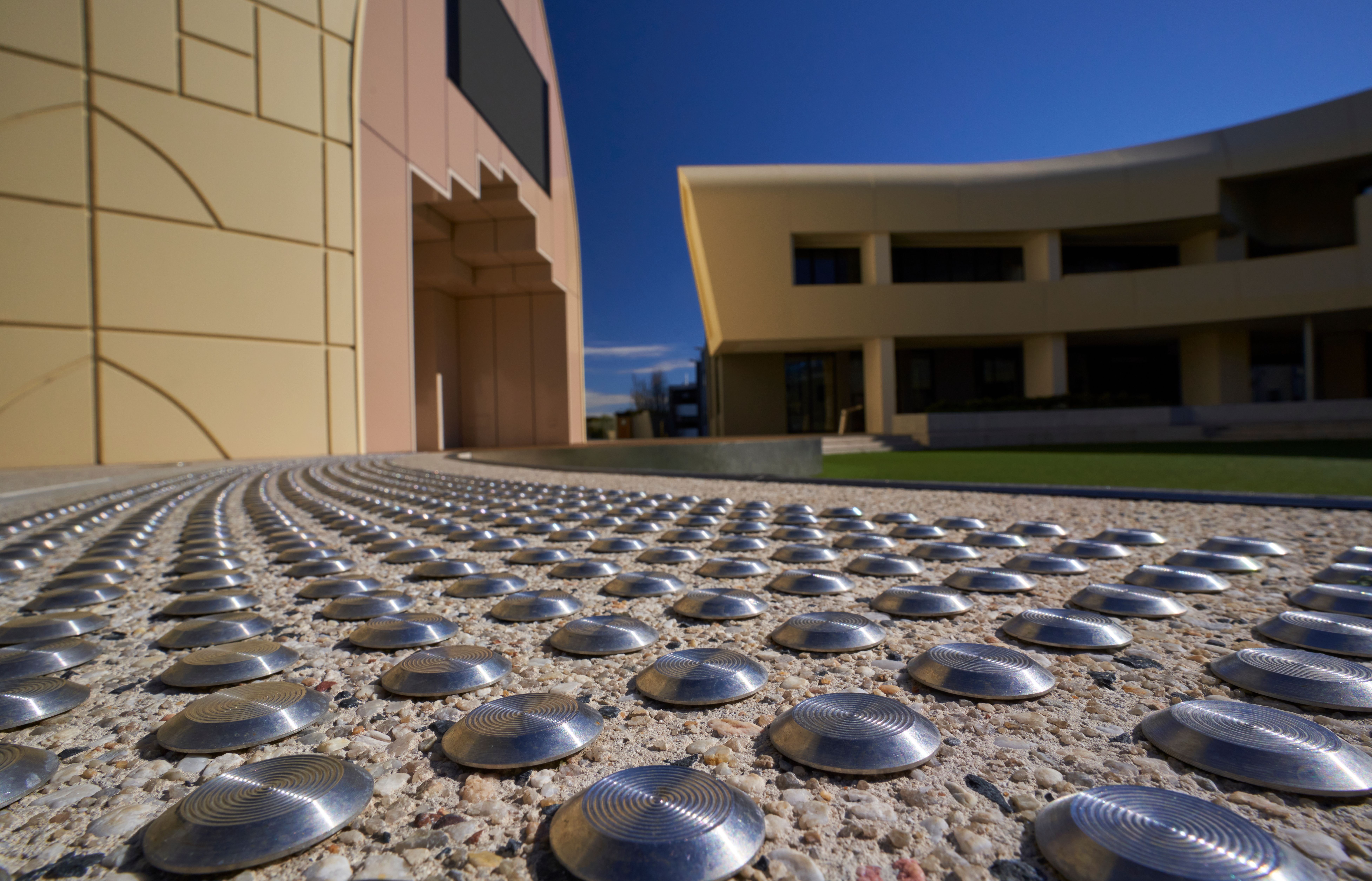 Grooved stainless steel tactile indicators installed outside a commercial building.
