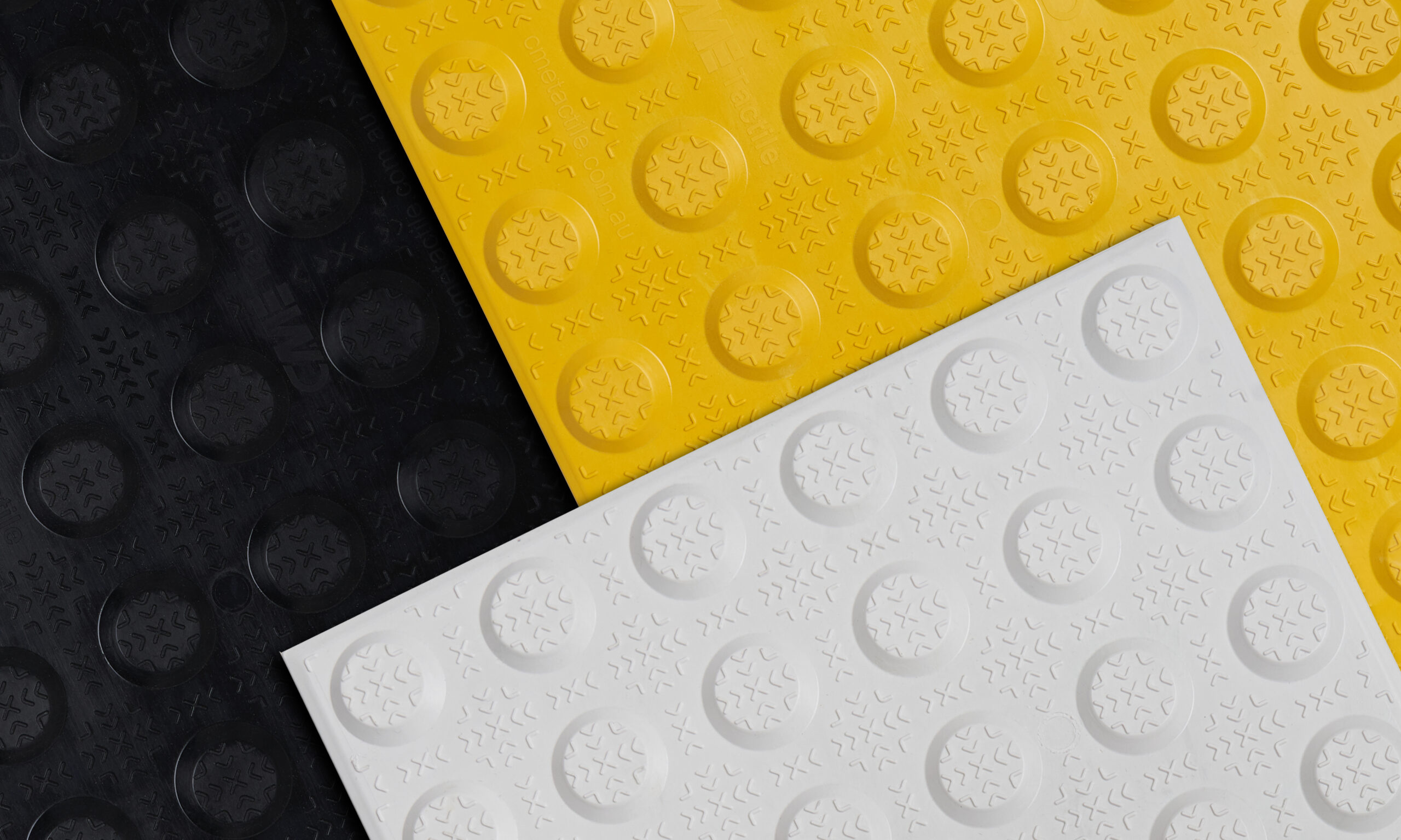 White, yellow and black fibreglass tactile plates placed next to each other.