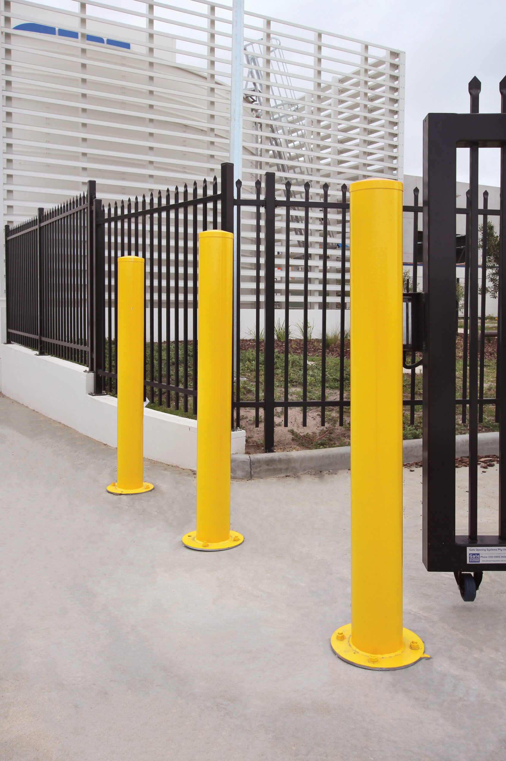 Surface mounted bollards installed in front of a commercial premises to restrict access.