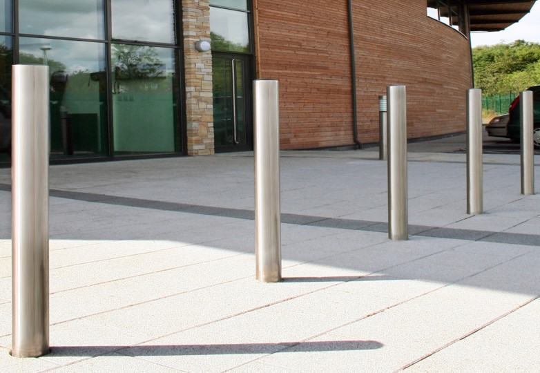 In ground bollards installed on the exterior entryway of a commercial building.