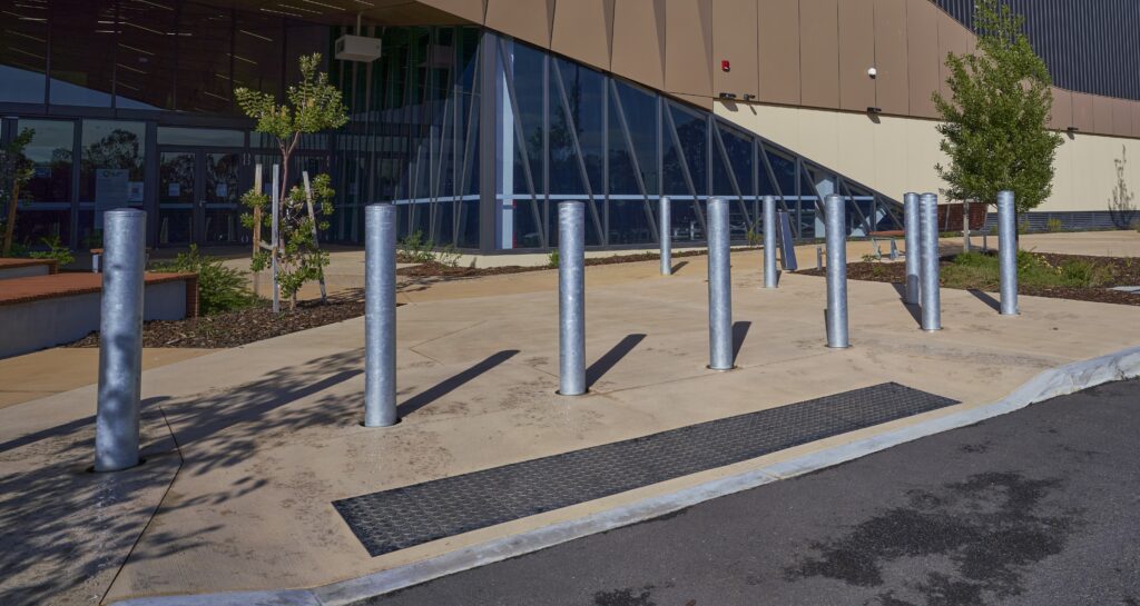 Safety bollards installed in front of a commercial building's entrance by Classic Architectural Group.