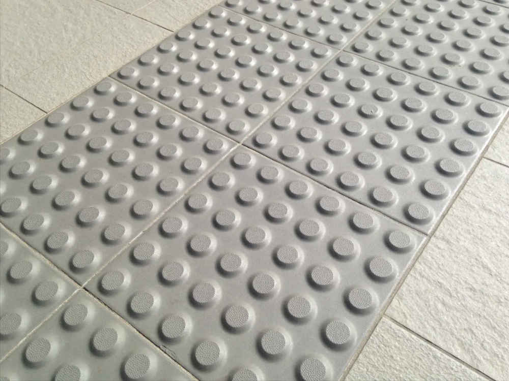 Concrete tactiles sitting flush with a tiled floor.