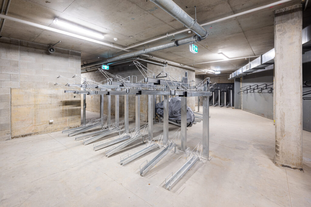 A well-lit concrete basement at 443 queen st with two-tier bike racks installed by Classic Architectural Group.